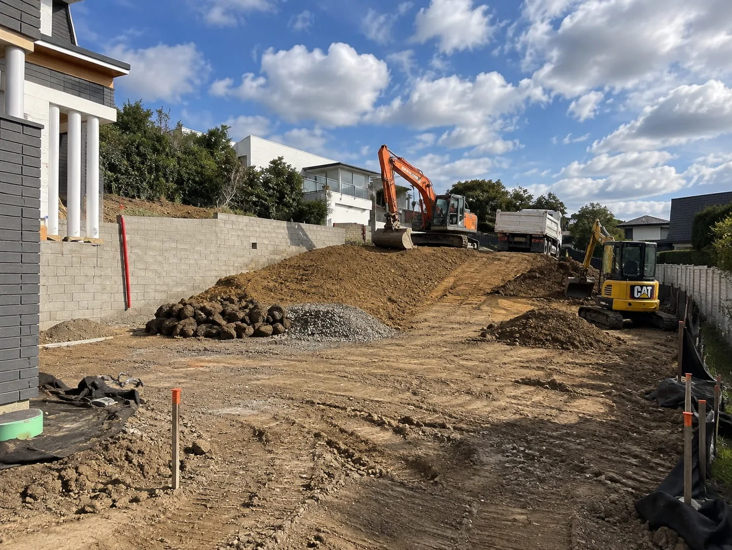 Excavator shaping a sloped Christchurch section